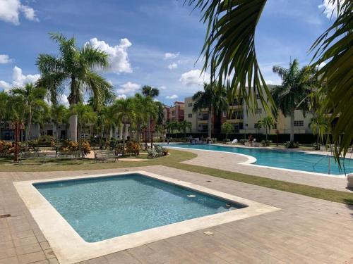 圣地亚哥洛斯卡巴VIP Home的棕榈树度假村内的游泳池