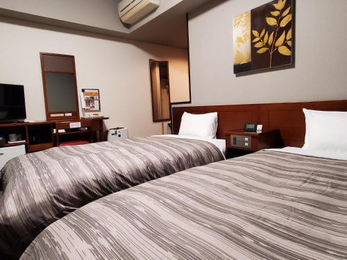 龟山龟山间路线酒店的酒店客房设有两张床和电视。