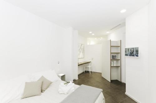 热那亚Genova Porto Antico Boutique Rooms的白色卧室配有床和书桌