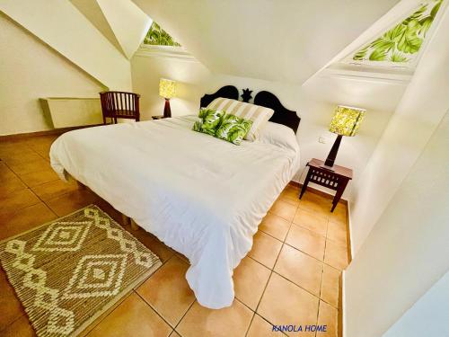 圣安尼KANOLA Home的卧室配有带绿色枕头的白色床