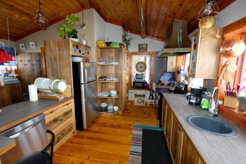Grenville-sur-la-RougeLe petit Montebello的铺有木地板的厨房和带冰箱的厨房