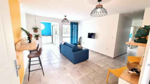 法兰西堡Le Marie-Agnès Appartement neuf de Standing的客厅配有蓝色的沙发和桌子