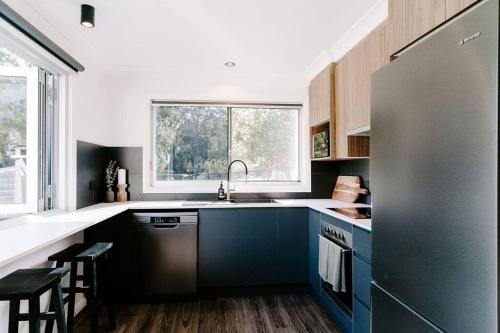 PyreeFarm & Sea Studio的一间设有蓝色橱柜和大窗户的厨房