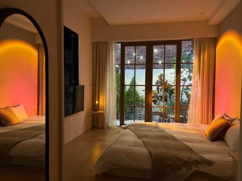 台南HoME-Easyhouse-III的一间卧室设有两张床和大窗户