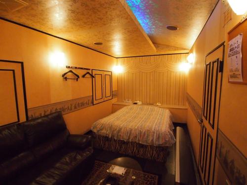 佐野市ホテルシンフォニー佐野店大人専用的小房间设有床和沙发