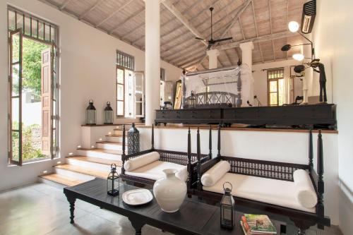 希克杜沃Haritha Villas & Spa的一间带桌子和一组楼梯的客厅