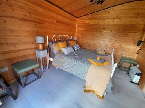 MochdreThe Hut B & B的一间卧室设有一张床和木墙