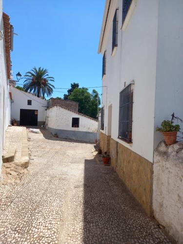 Cañaveral de LeónAgradable casa rural con chimenea y buenas vistas的远处的一条小巷,里面拥有建筑和棕榈树