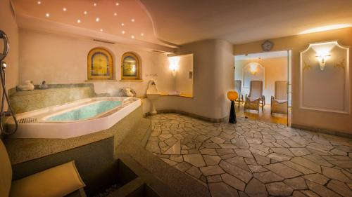 塞尔瓦迪加尔代纳山谷阿尔明酒店的带浴缸和盥洗盆的大浴室