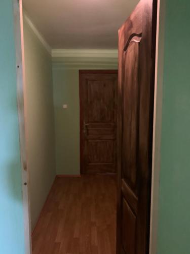 布达佩斯威廉姆斯村保龄球及乡村俱乐部酒店的一间空的走廊,房间里有木门
