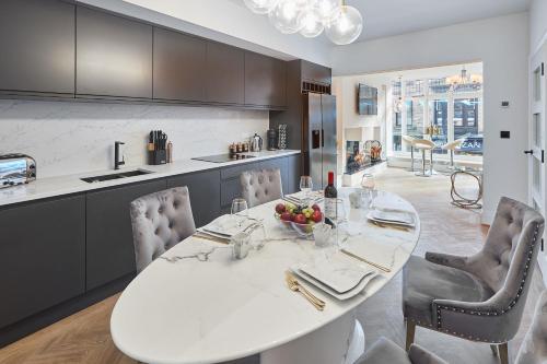 哈罗盖特Host & Stay - Oxford House的厨房以及带白色桌椅的用餐室。