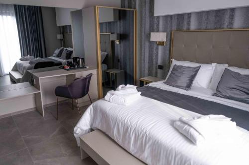 马斯卡卢恰Divina Charme的酒店客房设有一张大床和一张书桌。