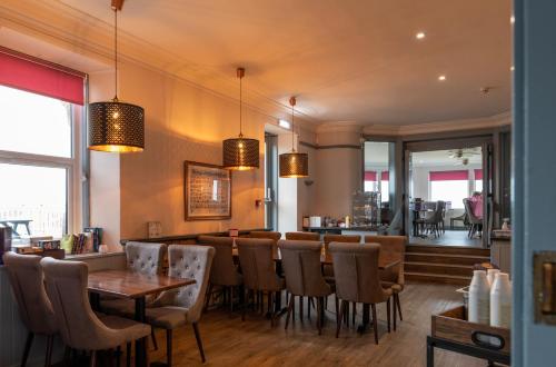 洛西茅斯GOLF View Hotel & Macintosh Restaurant的一间带桌椅的餐厅和一间酒吧