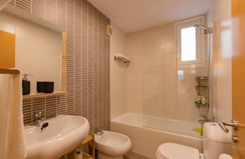 JoveArea Suites的带浴缸、盥洗盆和卫生间的浴室