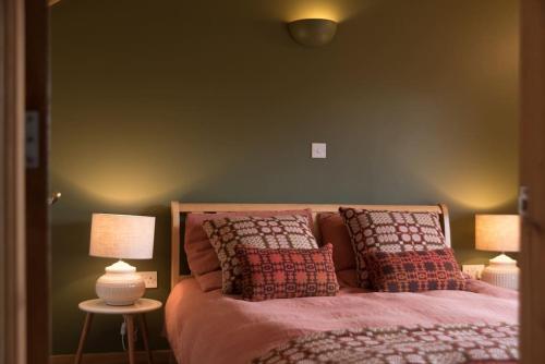 纽伯勒Tyddyn Plwm Isa的一间卧室配有一张带枕头的床和两盏灯。