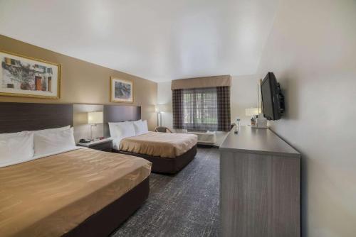 嘉年古德伊尔品质套房酒店的酒店客房设有两张床和一台平面电视。
