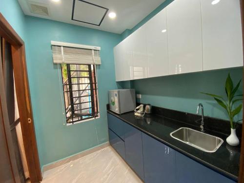 暹粒Siem Reap Homesteading的厨房设有蓝色的墙壁、水槽和窗户
