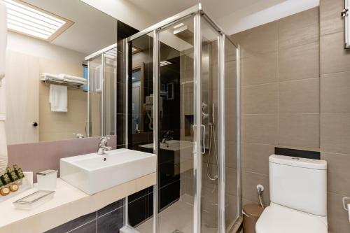 罗希姆诺棕榈海滩酒店式公寓的带淋浴、盥洗盆和卫生间的浴室
