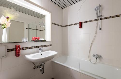 汉堡汉堡俄罗尔布克肯莱昂纳多酒店的白色的浴室设有水槽和浴缸。