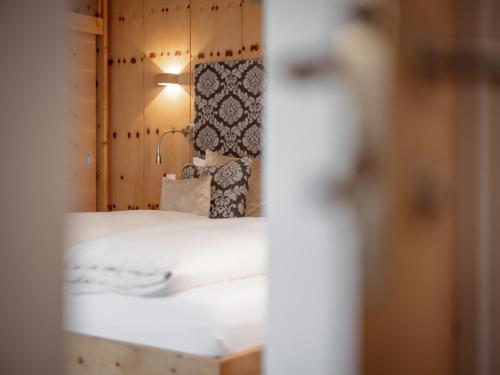 瑙德斯阿尔卑斯-舒适-中央酒店的一间卧室配有一张床,墙上配有一盏灯