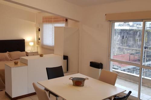 罗萨里奥Departamento luminoso amplio y silencioso.的厨房以及带桌椅的起居室。
