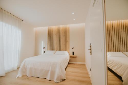 圣比森特德拉松谢拉Casa La Picuda的一间卧室配有两张床和镜子