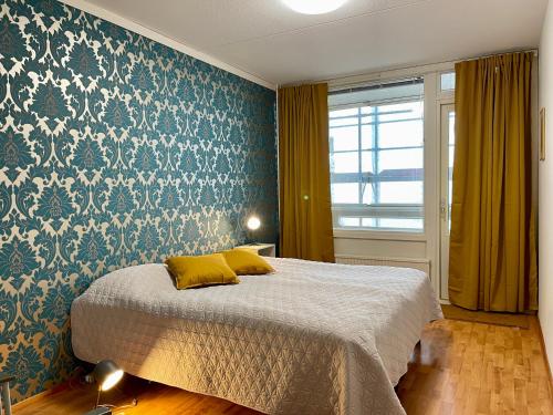 波尔沃Porvoon Kartanonpuisto的一间卧室配有一张蓝色和白色壁纸的床