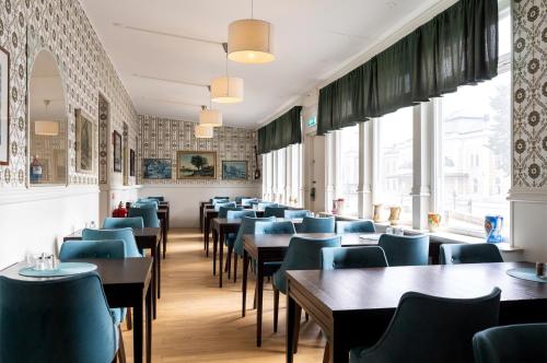 克里斯蒂安斯塔德Hotel Bishops Arms Kristianstad的一间配备有桌子和蓝色椅子的用餐室