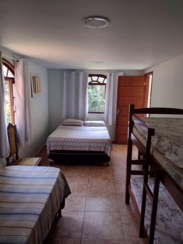 瓜拉派瑞Pousada Moinho D'água的一间卧室设有两张床和窗户。