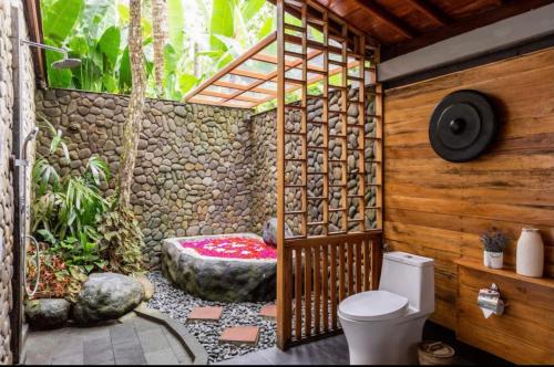 PenginyahanGovinda Villas的一间带卫生间和石墙的浴室