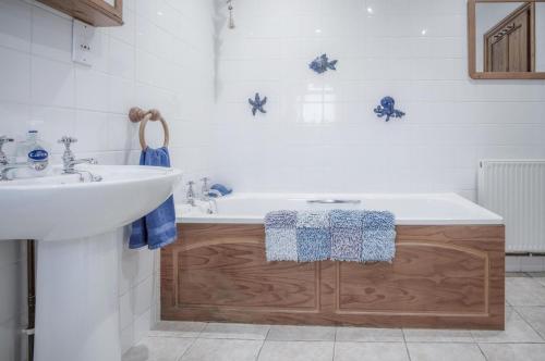 罗西里Fferm-Llong Cottage Ship Farm - 2 Bedroom -Rhossili的浴室配有白色浴缸和水槽