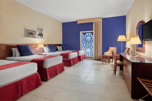 麦加玛卡利姆阿贝特酒店的酒店客房设有三张床和电视。