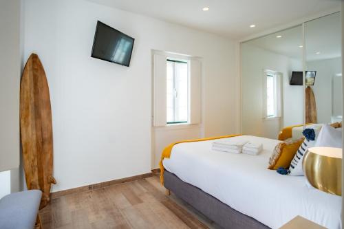 纳扎雷Feel Nazaré - Abegoarias 62的卧室配有一张白色大床和镜子