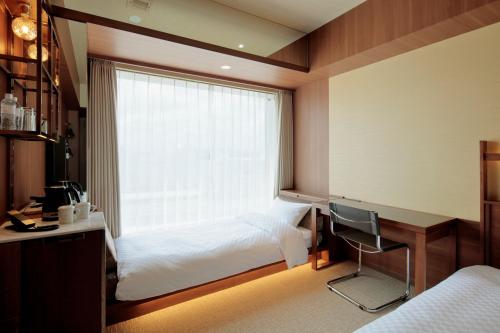 宇都宫Candeo Hotel Utsunomiya的一间卧室配有一张床、一张书桌和一个窗户。