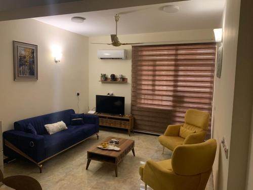 巴格达Dreams Apartments شقق الاحلام的客厅配有蓝色的沙发和两把椅子