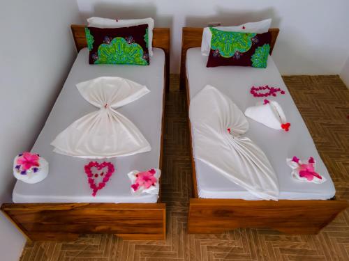 基济姆卡济Bella Vista Resort Zanzibar的两张带白色床单和鲜花的床