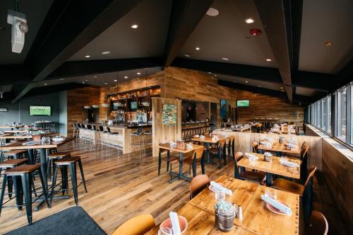帕克城帕克城山峰酒店的餐厅铺有木地板,配有桌椅