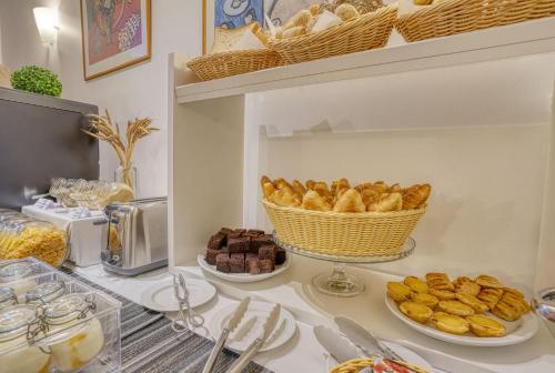 丰沙尔Vila Camacho Guest House的一张桌子,上面放着糕点盘和一篮面包