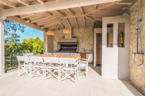康托卡利My Mediterranean Corfu Luxury Villa with Private Swimming Pool的庭院内带桌椅的户外厨房