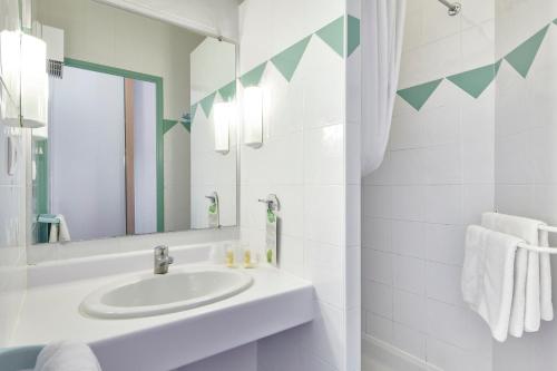 绍尔日Club Vacances Bleues Les Horizons du Lac (anciennement Serre-du-Villard)的白色的浴室设有水槽和镜子