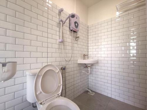 新山Maco Inn Century @Johor Bahru的白色的浴室设有卫生间和水槽。