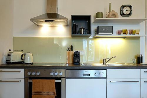 格拉茨Stilvolles Apartment in zentraler Lage的厨房配有水槽和炉灶 顶部烤箱