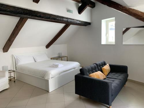 那不勒斯Folle Città B&B的一间卧室配有一张床和一张沙发