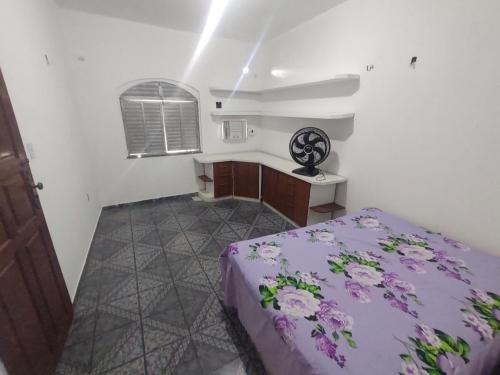 马瑙斯Casa grande em área central, bem iluminada e vent.的一间卧室配有一张紫色的床和一张书桌