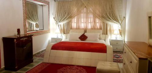 扎古拉Riad Jasmine Sud的一间卧室配有床和带窗帘的窗户
