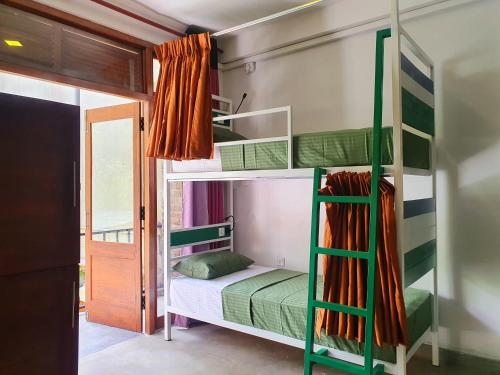 埃拉Downtown Hostel Ella的一间卧室配有带绿色双层床的双层床