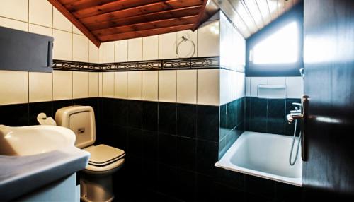 埃拉蒂特里卡隆Elation Woodhouse的浴室配有卫生间、盥洗盆和浴缸。