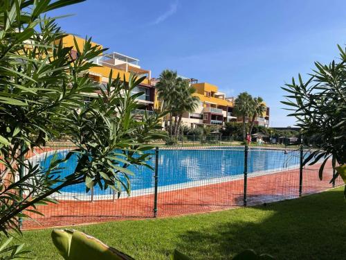 弗拉门卡海滩Casa Palmera - El Bosque - Playa Flamenca的游泳池前的网球场