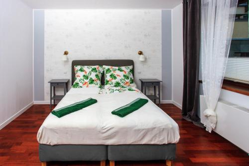 华沙Comfy Apartment Dobra 54的一间卧室配有一张带两个绿色枕头的床
