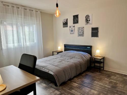 克莱蒙费朗F3 Centre- Ville Lafayette avec garage的一间卧室配有一张床、两张桌子和两盏灯。